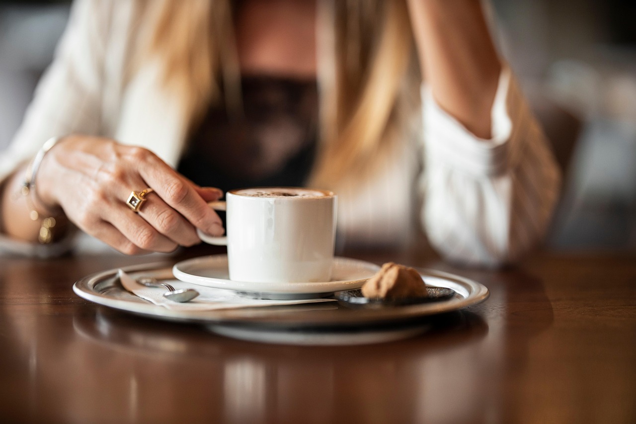 Caffè servito su un tavolo, con un orologio che segna le ore dopo pranzo, simbolo di consumo consapevole.